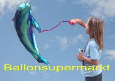 Kinder und Luftballons - Mädchen spielt mit Delfin-Luftballon